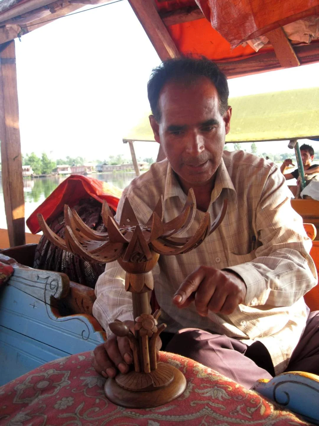 A Srinagar artisan holding a carved wooden piece