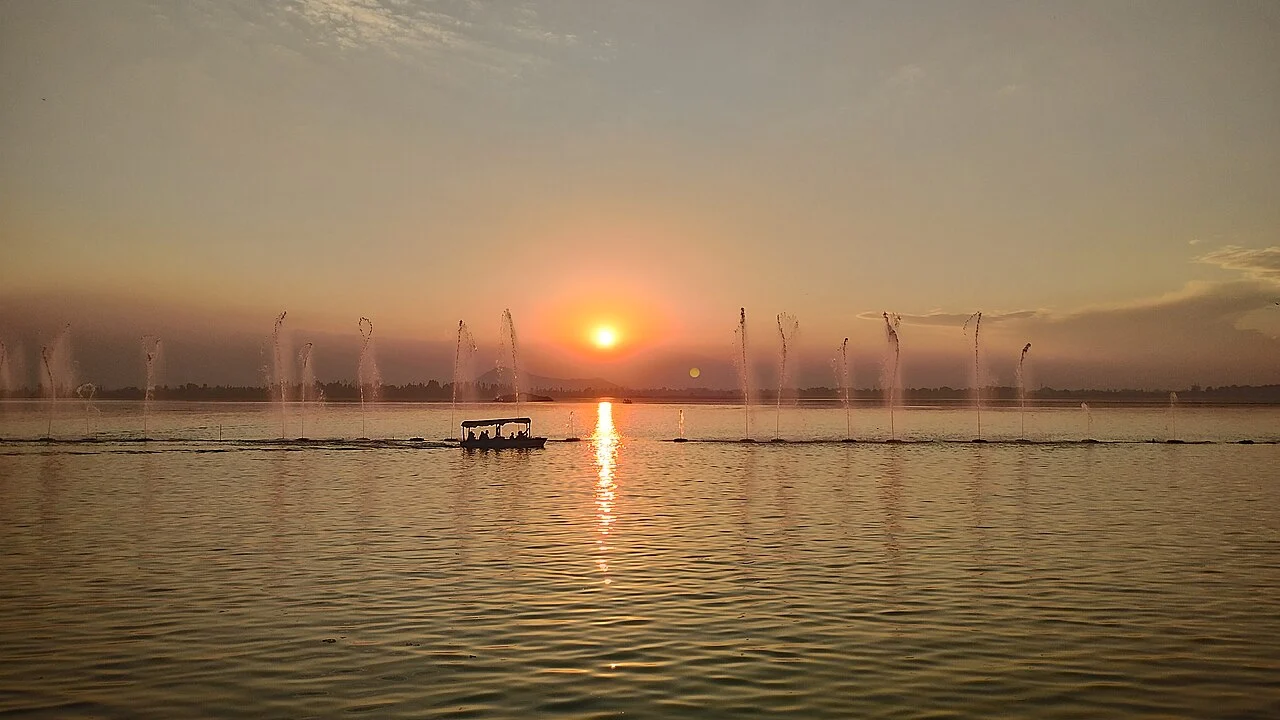 A shikara crossing the lake at sunset