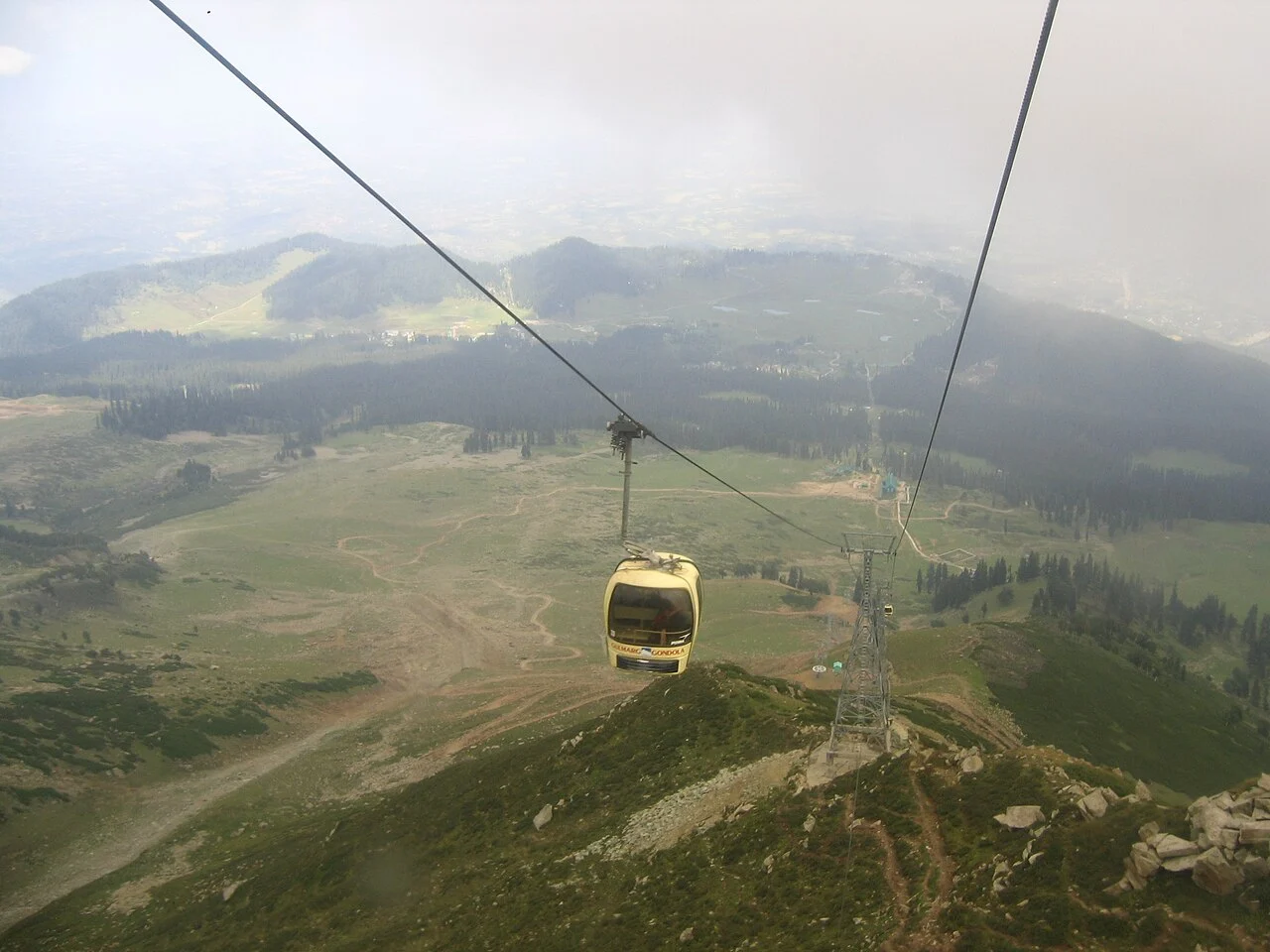 The Gulmarg gondola rising over green slopes