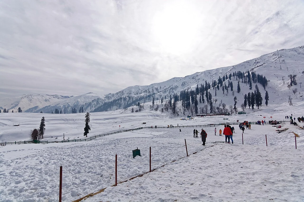 Snow-covered slopes in Gulmarg with skiers and walkers