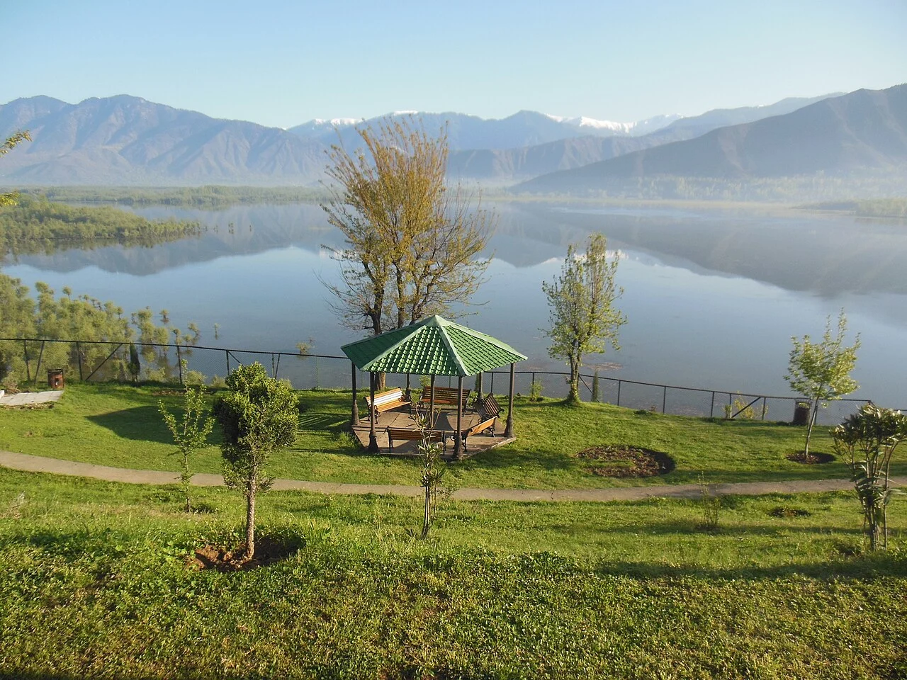 Wular Lake seen from a grassy shore with a small pavilion