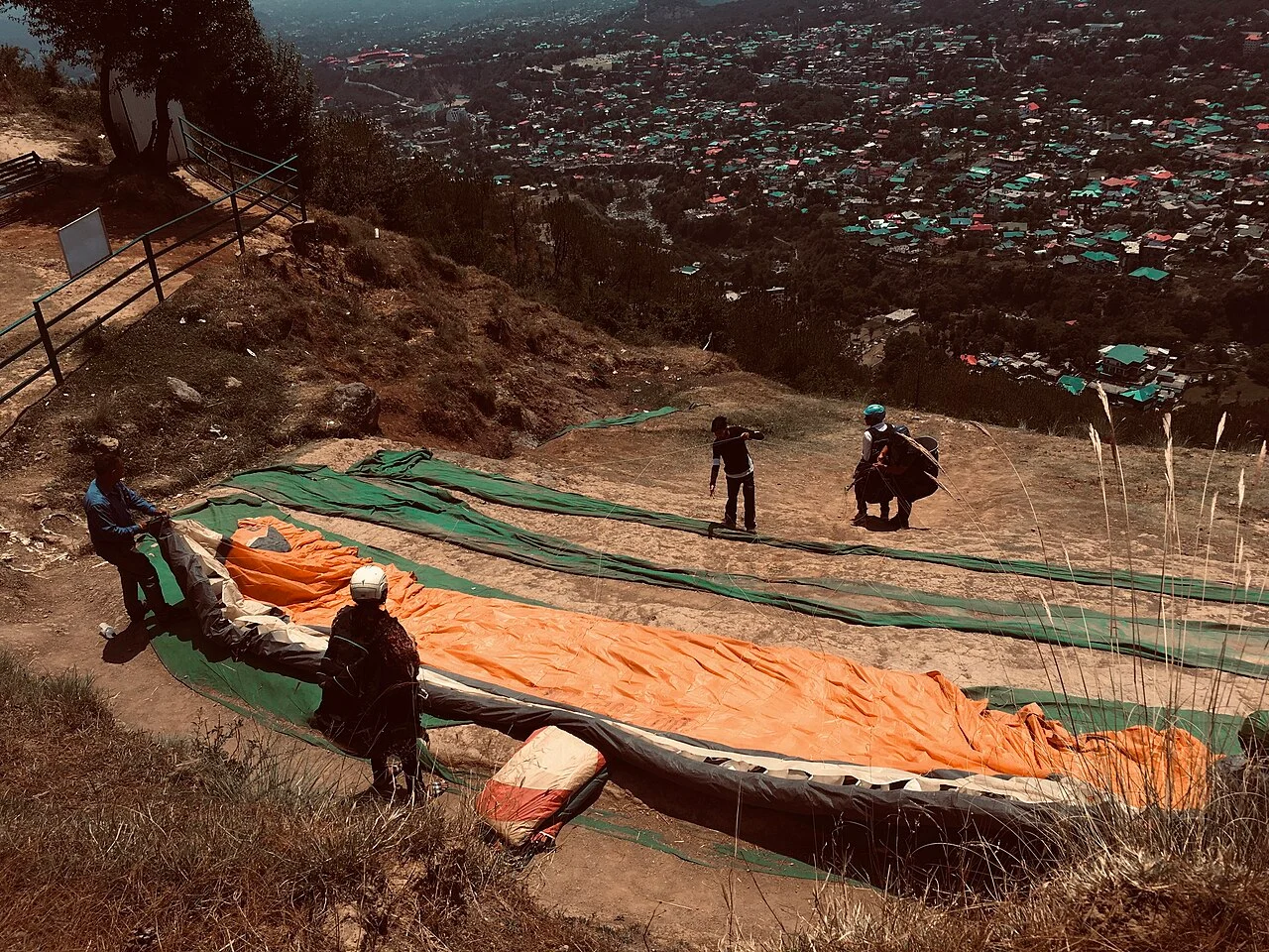 A paraglider laid out and ready for launch on a hillside